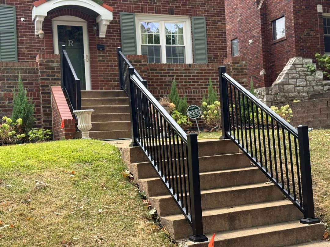 Brick house with a landscaped front yard and accessible metal railing on stairway.
