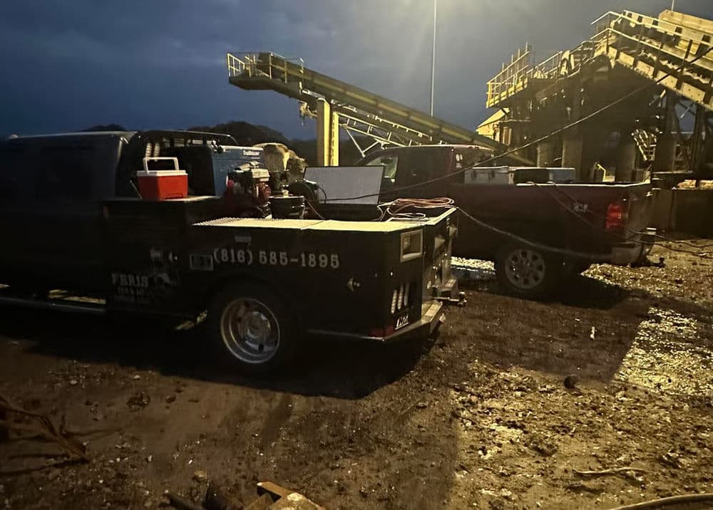 Heavy machinery and trucks at an industrial site during twilight, highlighting work operations.